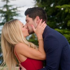 vanessa and logan kiss at the commitment ceremony on an outdoor balcony in age of attraction