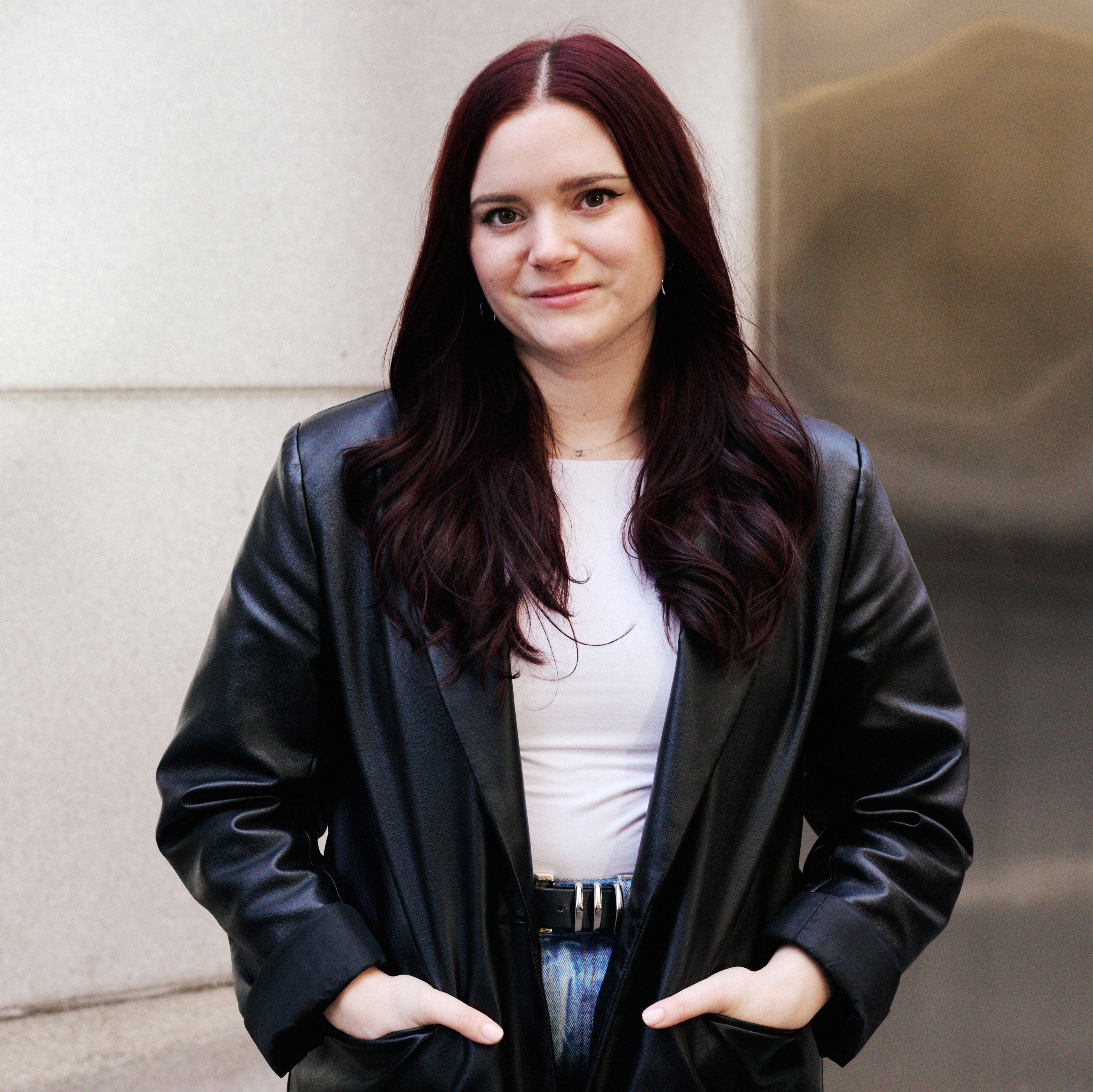 brooke knappenberger marie claire associate commerce editor posing with leather jacket with heads in pockets 